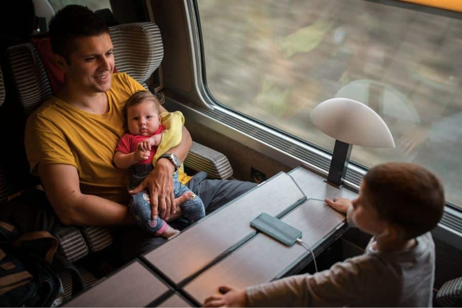 Père et enfants dans un compartiment de train.