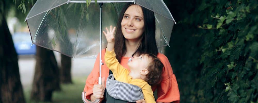 Mère et enfant sous parapluie transparent.