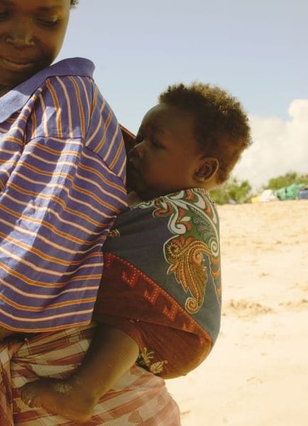 Le portage en Afrique - petit bébé porté dans le dos à l'aide d'un tissu coloré