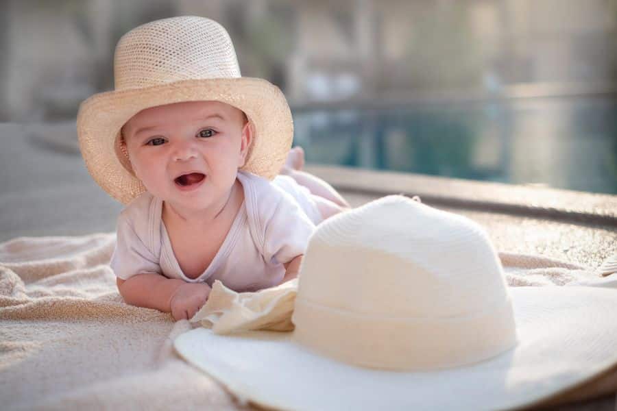 Bébé souriant avec chapeau de paille.
